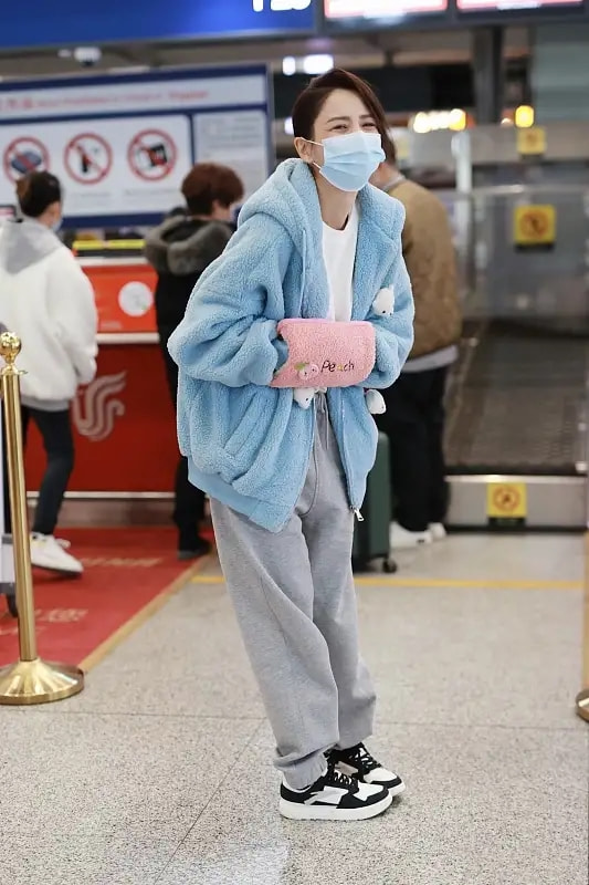 Tong Liya appeared at the airport, hot water bottle and plush jacket ...